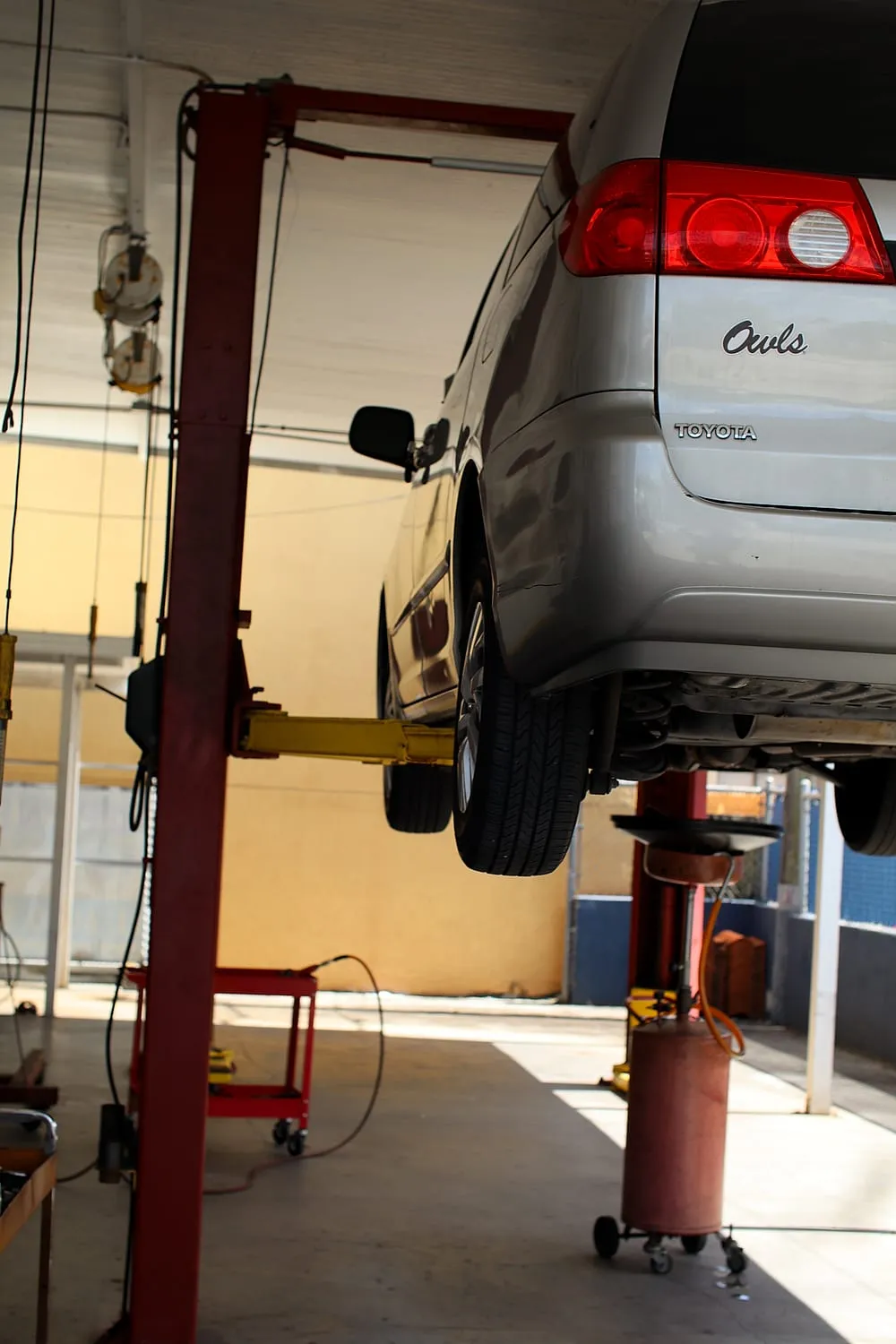 Suspension work on a vehicle raised on a lift at Japanese Auto Tech