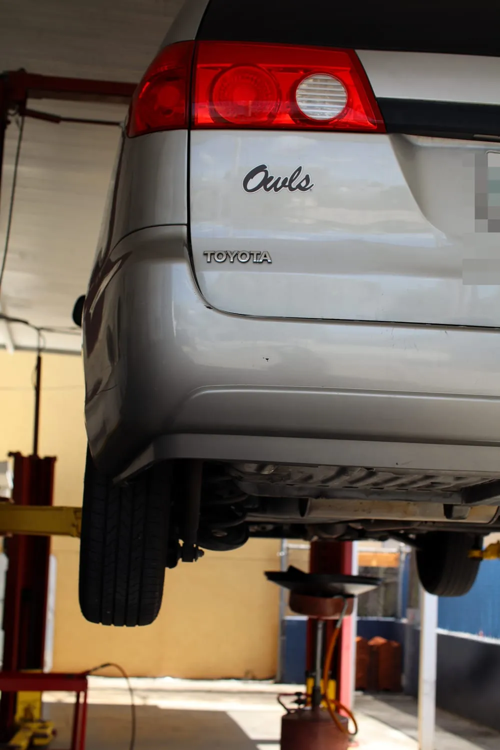 A vehicle raised on a lift for brake service at Japanese Auto Tech in Miami
